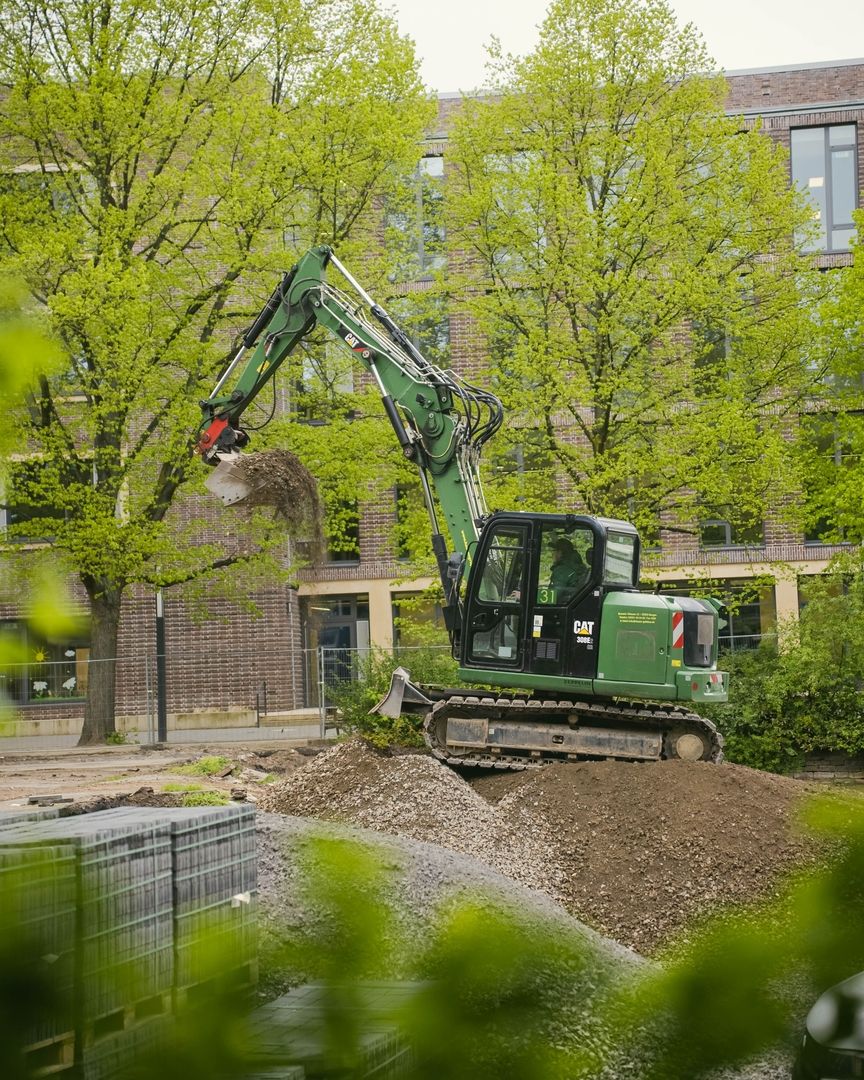 Ein Bagger steht in einem Garten zum Umgraben